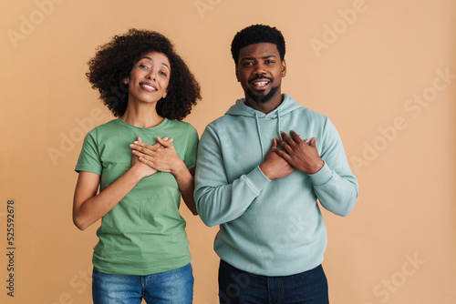 Fotografie Black man and woman expressing dignity and keeping hands at heart