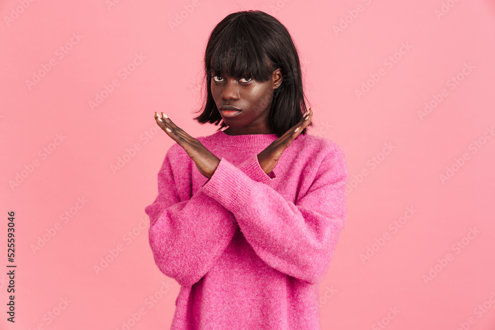 Young beautiful african woman in pink sweater with crossed arms Young beautiful african woman in pink sweater with crossed arms