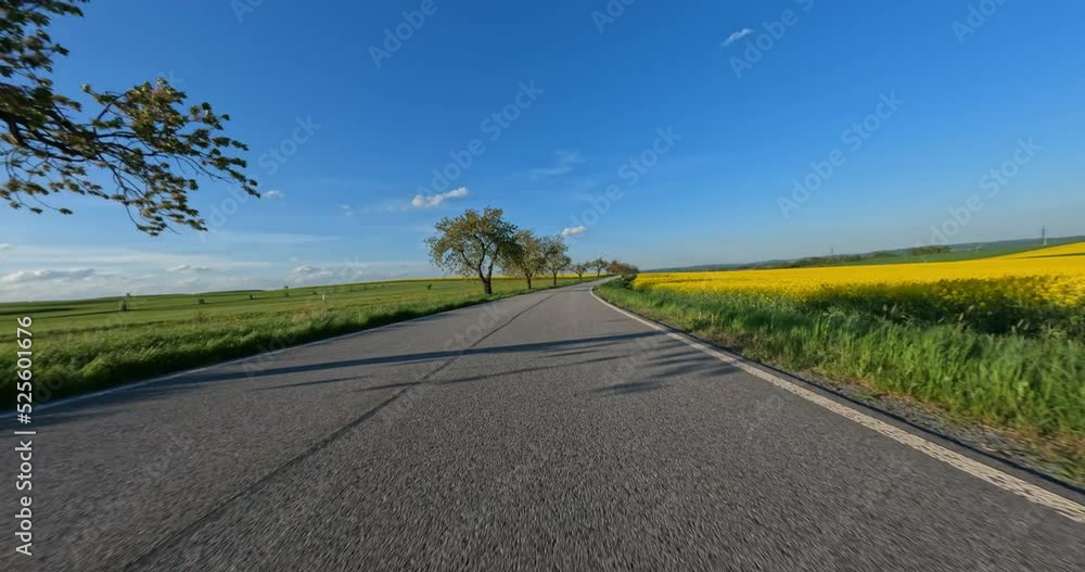 Spring trip by car around blooming fields and trees on county road. Countryside landscape from camera on moving vehicle. Czech Republic Spring trip by car around blooming fields and trees on county road. Countryside landscape from camera on moving vehicle. Czech Republic