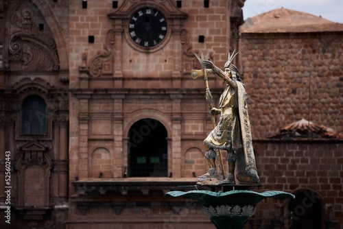 Monument to Atahualpa the ruler of Incas in front of old buildings photo