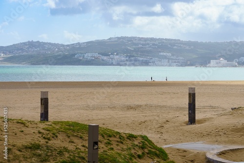 Aerial view of sea waves breaking beach surrounded by hills with buildings