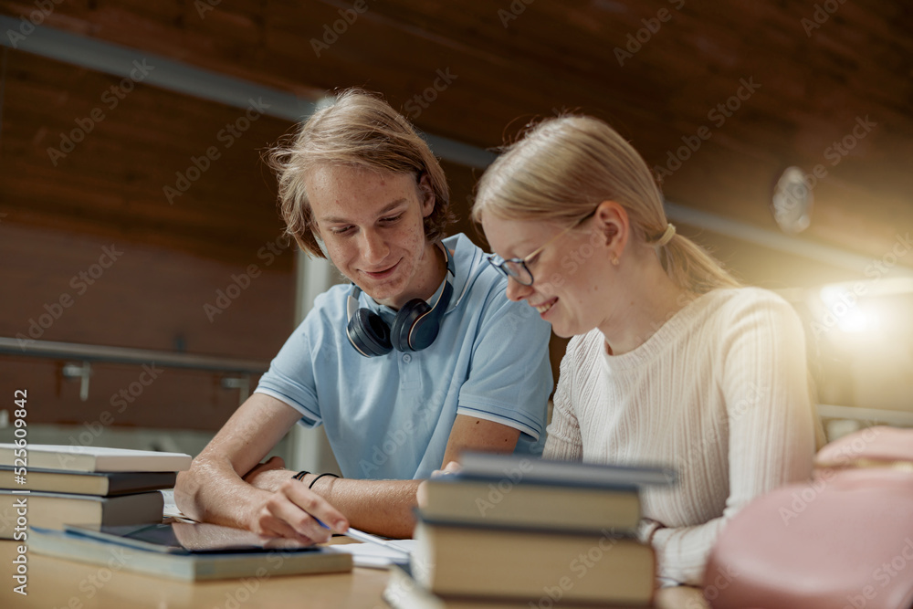 Students sit in the library and take notes while preparing for the exam Students sit in the library and take notes while preparing for the exam