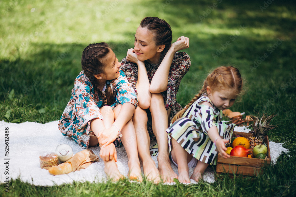 Fototapeta premium Mother with daughters having picnic in park 