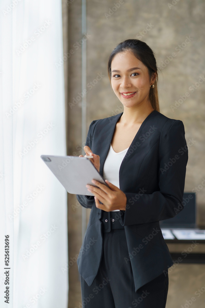 Beautiful Asian businesswoman standing confidently preparing for work. Beautiful Asian businesswoman standing confidently preparing for work.