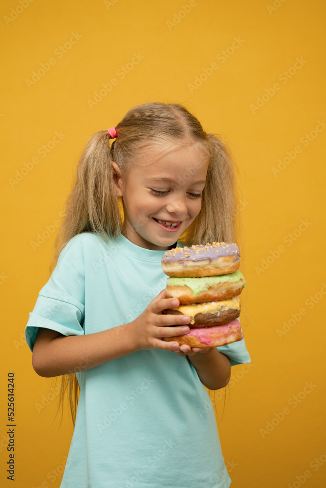 Funny girl with donuts on a yellow background Funny girl with donuts on a yellow background