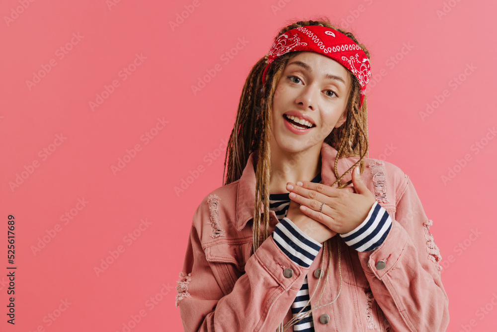 White woman with dreadlocks smiling while holding hands on her chest White woman with dreadlocks smiling while holding hands on her chest