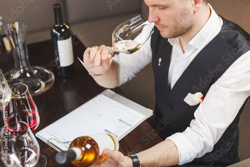 Wallpaper Mural Wine waiter smells white drink in wineglass in winehouse.