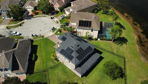 Billede på lærred Bird's eye view of houses with solar panels on rooftops in a green residential d