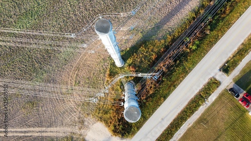 Overhead view of powerlines near a road with cars parked near it photo