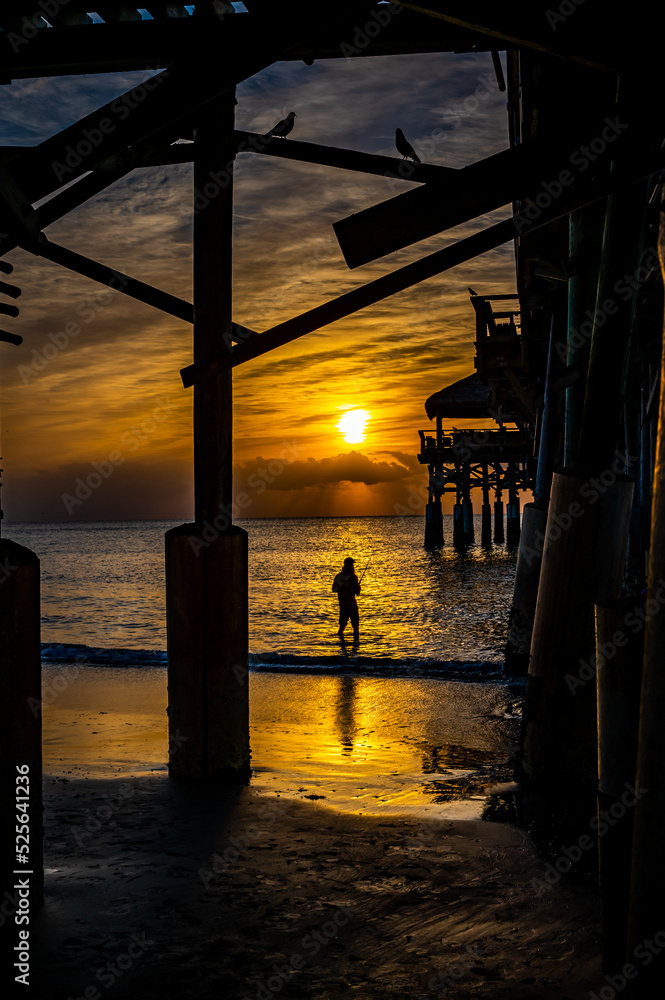 Fishing at sunset in front of the pier