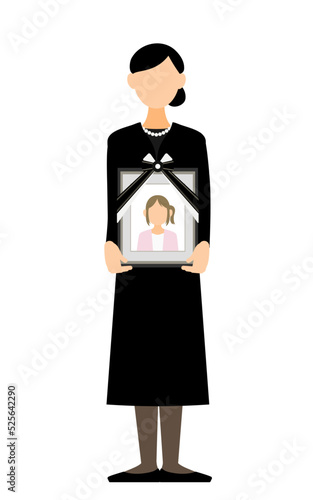 娘の遺影を持って立つ若い女性