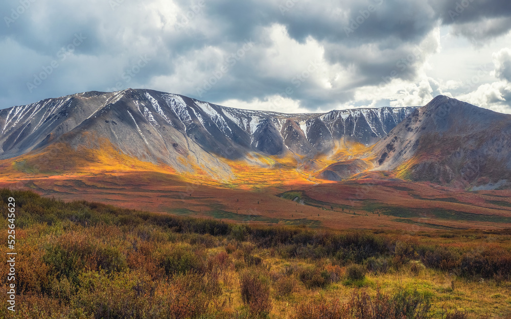 Picturesque autumn mountain plateau with a dramatic view and rays of the sun on the hillside.