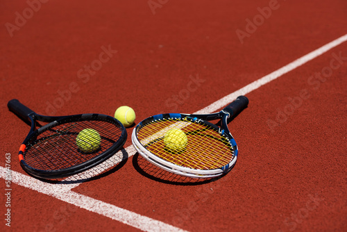 Tennis racquets with tennis balls on clay court. © Angelov