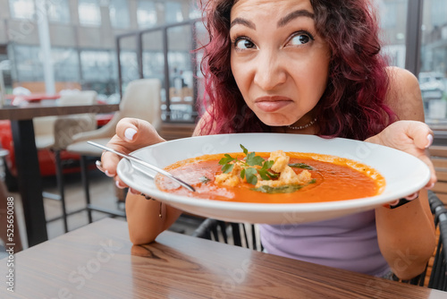 Schilderij op canvas A woman dissatisfied customer of the restaurant sniffs the disgusting smell of a
