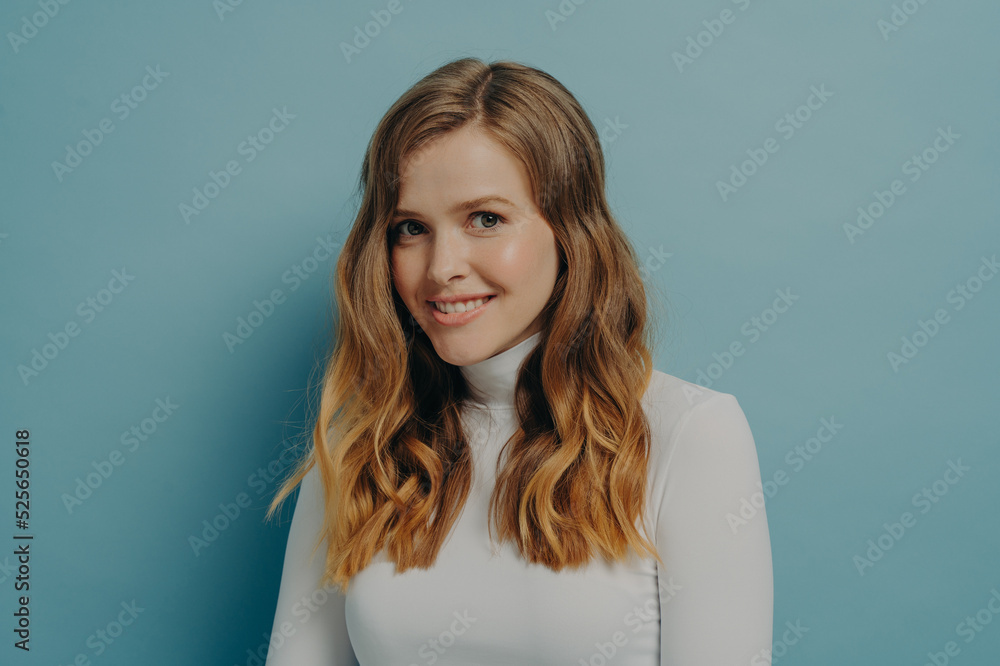 Young charming happy woman looking at camera smiling brightly and expressing positive emotions Young charming happy woman looking at camera smiling brightly and expressing positive emotions
