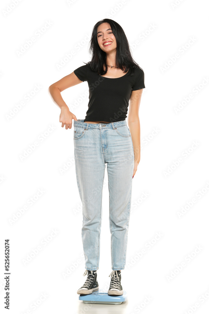 Weight loss happy woman standing on a scale, isolated on a white background. Slim Body Weight loss happy woman standing on a scale, isolated on a white background. Slim Body