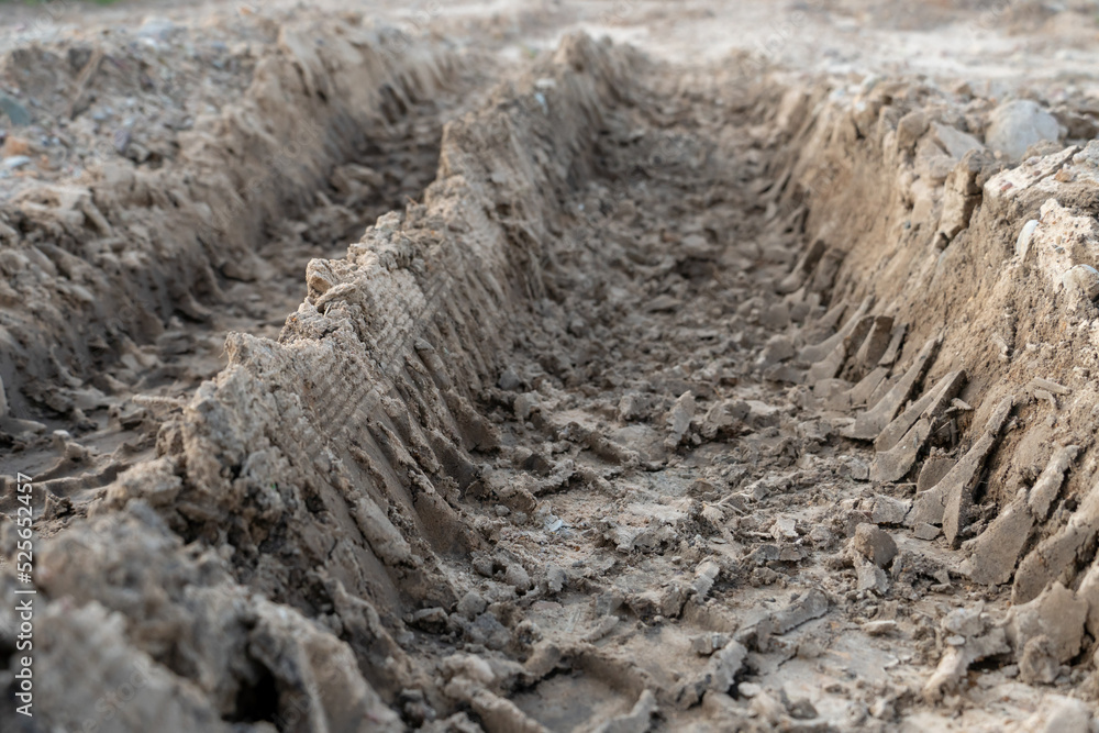 A deep car track on a Russian dirt road after rain. The imprint of car tires on the dirt. Dried mud on the roads in the village. A deep car track on a Russian dirt road after rain. The imprint of car tires on the dirt. Dried mud on the roads in the village.