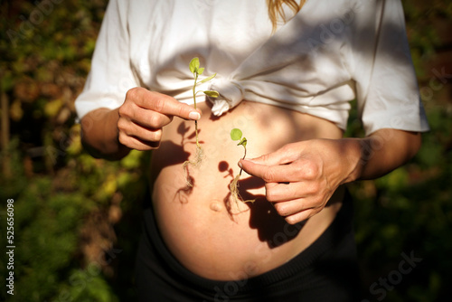 Pregnant woman with two sprouted plants expecting twins