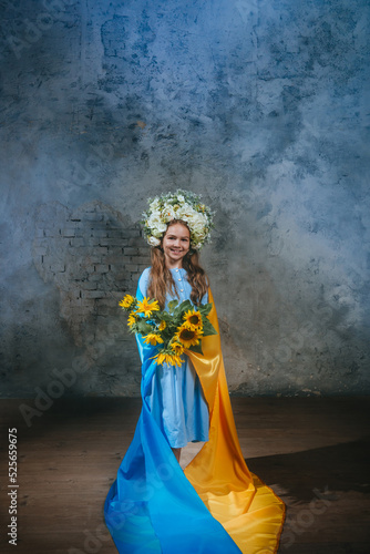 Little girl in ethnic dress wearing flower wreath with Ukrainian flag