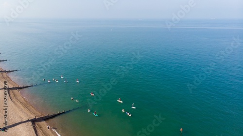 Drone shot of beach and Seafront with paddle boarders in Tankerton in Kent, United Kingdom photo