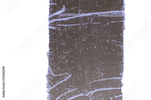 Strip of tape adhesive on a glass surface after being pulled.  