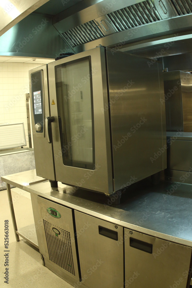 restaurant kitchen interior with self cooking center on foreground restaurant kitchen interior with self cooking center on foreground