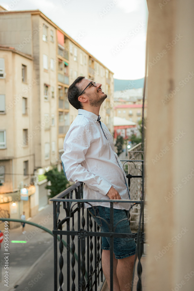 Happiness man smiles and poses in a balcony