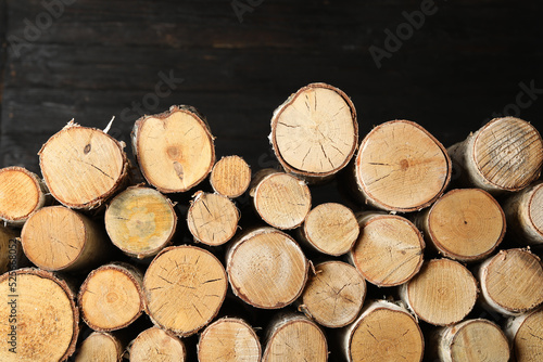 Cut firewood on black background. Heating in winter