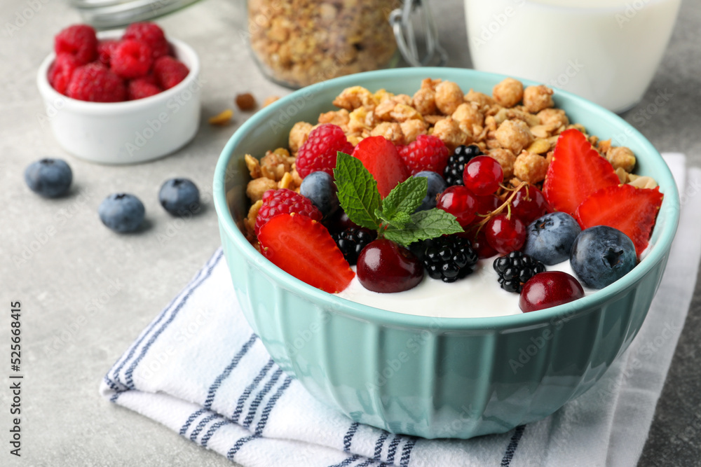 Bowl with tasty granola and berries on light grey table, closeup. Healthy meal Bowl with tasty granola and berries on light grey table, closeup. Healthy meal