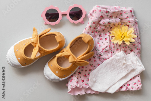 Stylish child clothes, shoes and accessories on grey background, flat lay