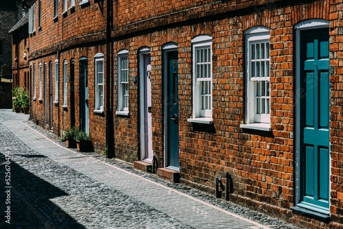 Brick building on a cobblestone street with wooden doors and white windows in Farnham, England photo