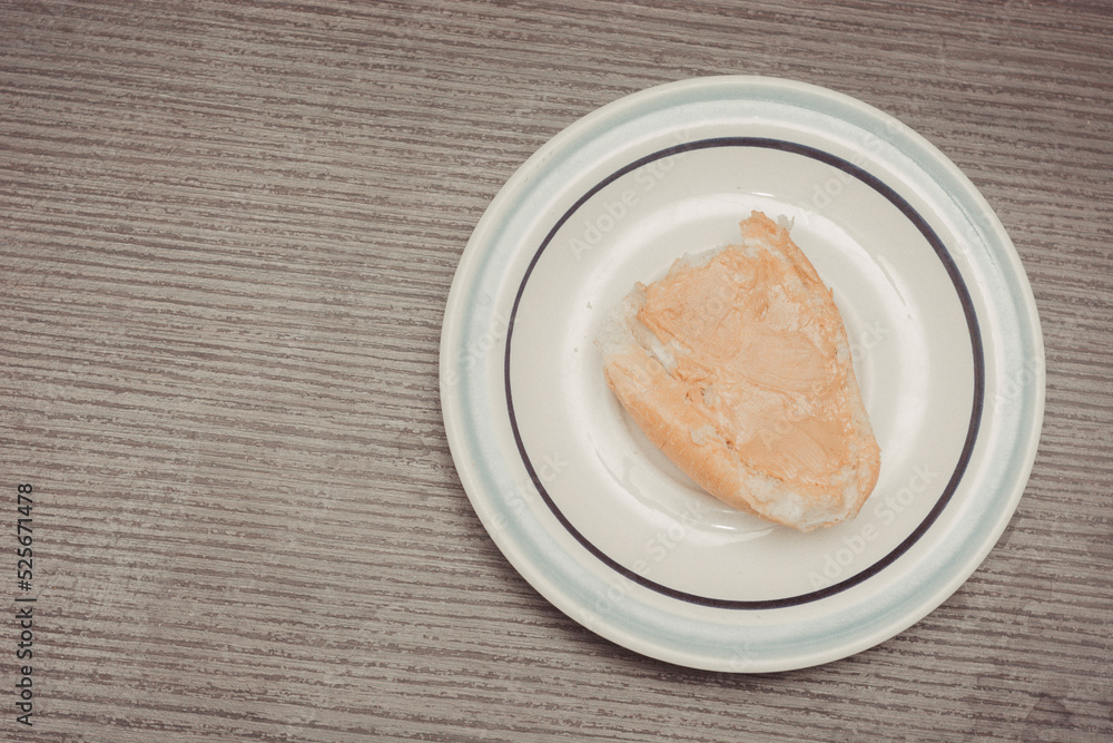 French toast, individual serving with ready-to-spread peanut butter on white ceramic plate with isolated wooden background. French toast, individual serving with ready-to-spread peanut butter on white ceramic plate with isolated wooden background.