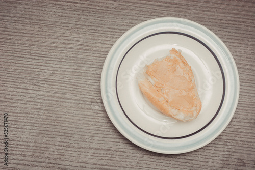 French toast, individual serving with ready-to-spread peanut butter on white ceramic plate with isolated wooden background.