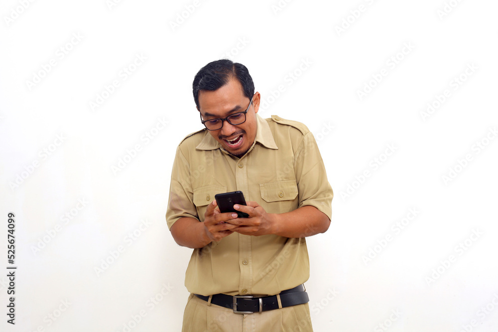 Happy Indonesian government employees standing while getting good news from his cell phone Happy Indonesian government employees standing while getting good news from his cell phone