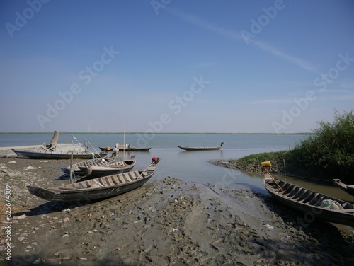 Boats on the shore in Yoe Ngu Village, Myanmar, on a sunny day photo