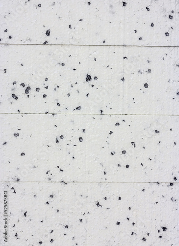 Styrofoam pile as background. White with black dots. Building material for thermal insulation of buildings.