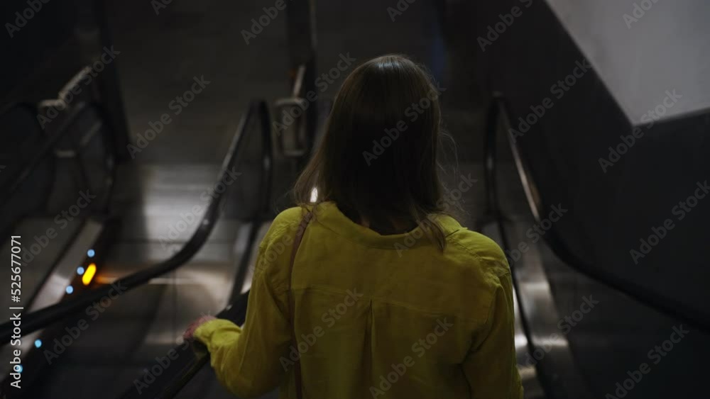 Woman using an escalator in metro. Woman using an escalator in metro.