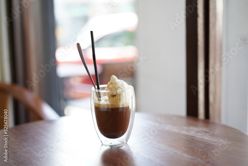 Ice cream coffee in double layer glass on wooden table