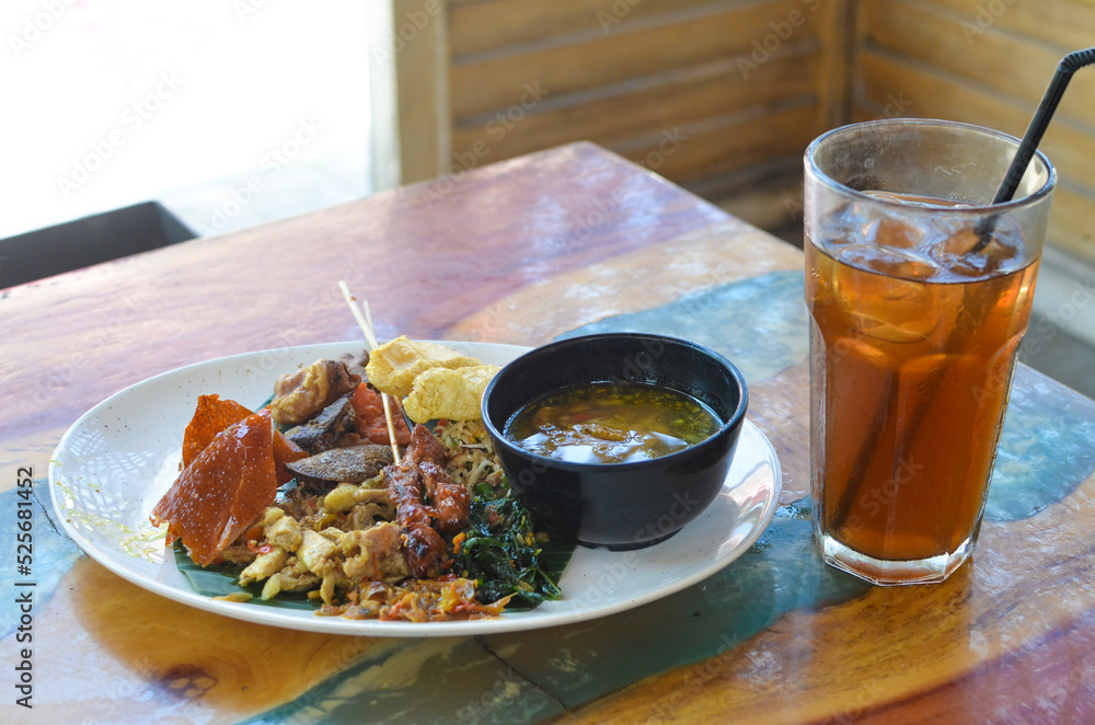 a photo of balinese rice dish of roast pork or usually called nasi campur babi guling with natural light. a photo of balinese rice dish of roast pork or usually called nasi campur babi guling with natural light.