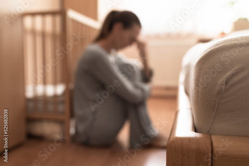 Tired, exhausted, mother, wife at home sitting on bedroom floor. 