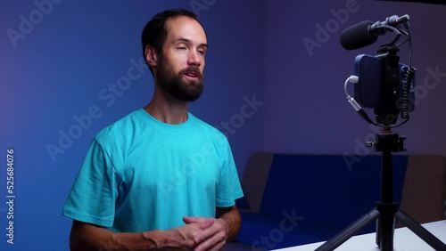 A young blogger records a video with himself on his phone in his studio. photo