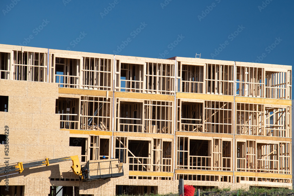 New apartment building under construction on sunny day on blue sky background New apartment building under construction on sunny day on blue sky background
