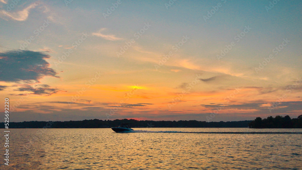 Beautiful sunset on Lake Norman, North Carolina - boat moving across calm water