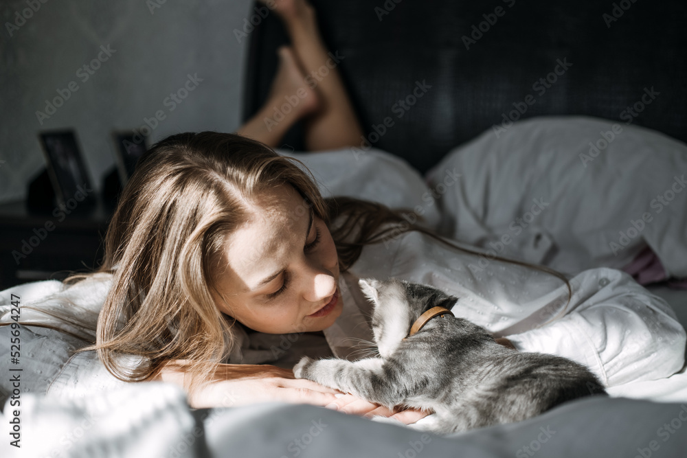 Mindfulness, Being in the present moment, here and now. Young woman play with kitten at home in morning