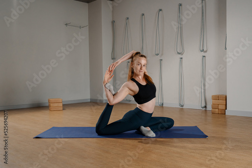 Athletic woman doing pilates yoga stretching for health in the studio. athletic body girl