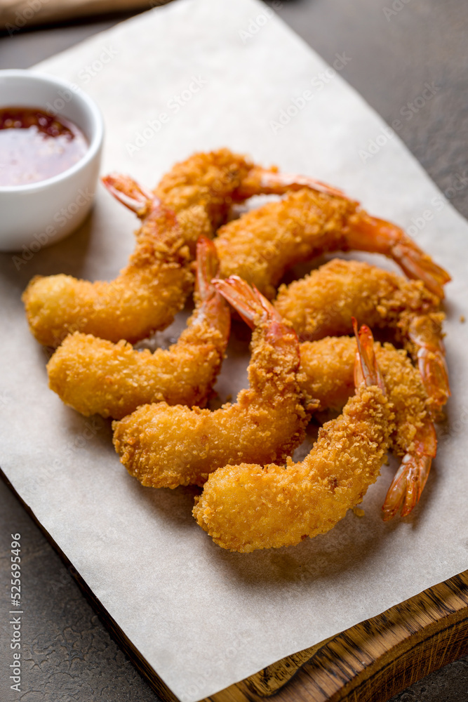 fried tempura shrimps on the board with sweet chili sauce on table, vertical macro close up fried tempura shrimps on the board with sweet chili sauce on table, vertical macro close up