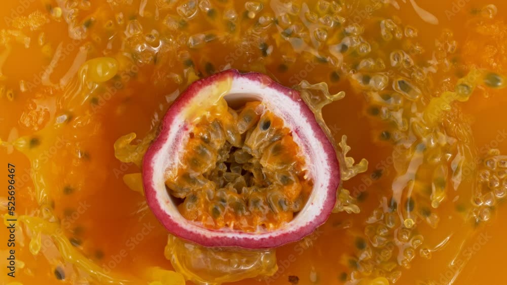 Fresh sliced passion fruit falling into juice, super slow motion filmed on high speed cinematic camera at 1000 fps. Fresh sliced passion fruit falling into juice, super slow motion filmed on high speed cinematic camera at 1000 fps.