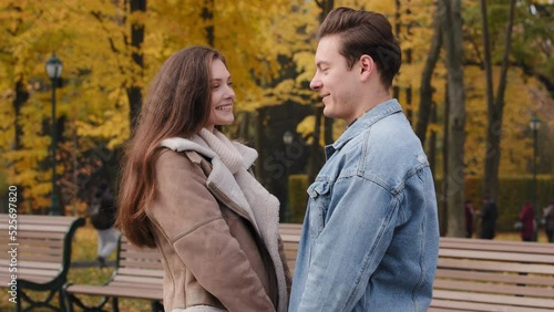Caucasian young couple lovers married family teenagers stand closeness together in autumn park relationships on romantic date beautiful girl talk with handsome caring boyfriend joy laughing outdoors
