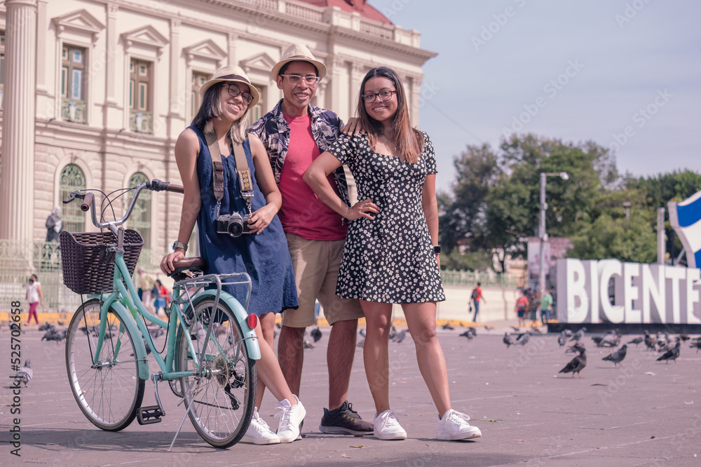 Portrait of young Hispanic friends with bicycles in the central park in  El Salvador.