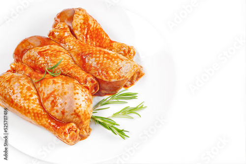 Baner.Cooking chicken drumsticks.Raw chicken legs in a marinade with rosemary on a background.Top view, copy space.Isolated.Marinated chicken dramstick with spices for cooking. photo